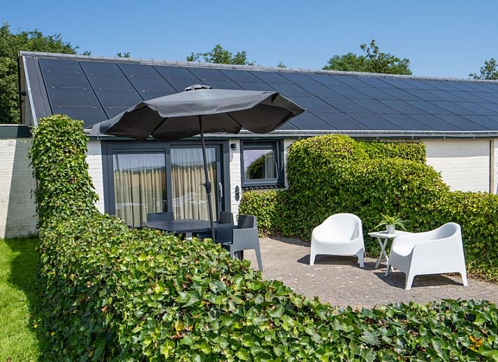 Bungalow 2 in De Koog, Texel met zonnig terras en tuinmeubilair, ideaal vakantiehuis op de Waddeneilanden.