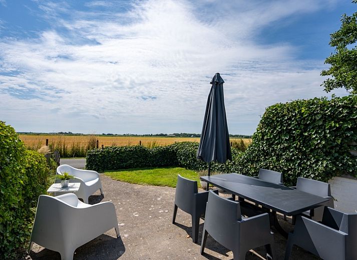 Bungalow 2 in De Koog, Texel met zonnig terras en tuinmeubilair, ideaal vakantiehuis op de Waddeneilanden.