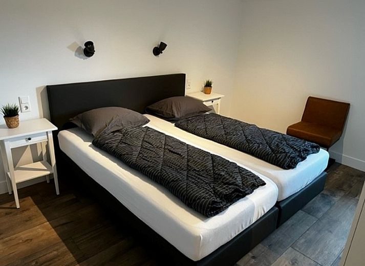 Terras van Bungalow 2 in De Koog, Texel met parasol en zitgelegenheid, perfect voor ontspanning op de Waddeneilanden.