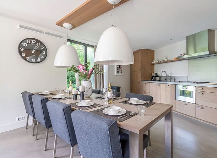 Gemuetliches Wohnzimmer im Ferienhaus in De Koog, Texel, mit grossen Fenstern und Blick auf die Natur, perfekt fuer Entspannung auf den Watteninseln.