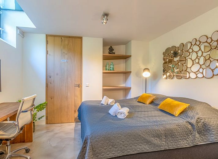 Gemuetliches Wohnzimmer im Ferienhaus in De Koog, Texel, mit grossen Fenstern und Blick auf die Natur, perfekt fuer Entspannung auf den Watteninseln.