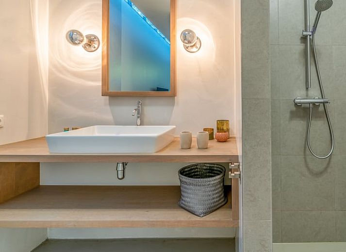 Der offene Wohnbereich im Ferienhaus in De Koog, Texel, mit Blick auf die Kueche und den Essbereich, bietet eine gemuetliche Atmosphaere auf den Watteninseln.