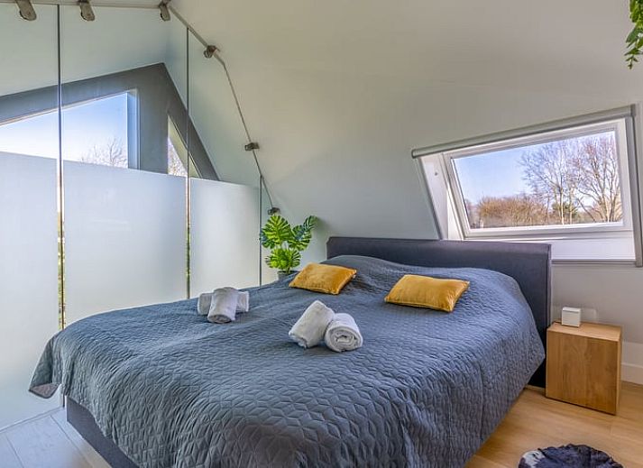 Der offene Wohnbereich im Ferienhaus in De Koog, Texel, mit Blick auf die Kueche und den Essbereich, bietet eine gemuetliche Atmosphaere auf den Watteninseln.