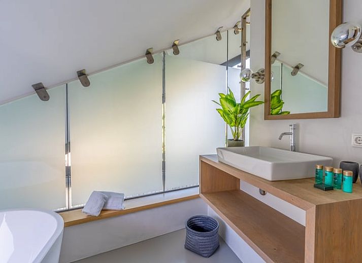 Der offene Wohnbereich im Ferienhaus in De Koog, Texel, mit Blick auf die Kueche und den Essbereich, bietet eine gemuetliche Atmosphaere auf den Watteninseln.