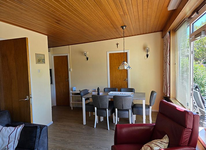 Gezellige woonkamer van Bungalow 47 in Bungalowpark De Nagtegaal, De Koog, Texel met comfortabele stoelen en houten interieur.