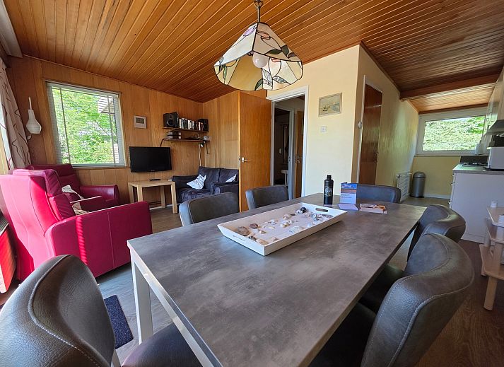 Gezellige woonkamer van Bungalow 47 in Bungalowpark De Nagtegaal, De Koog, Texel met comfortabele stoelen en houten interieur.