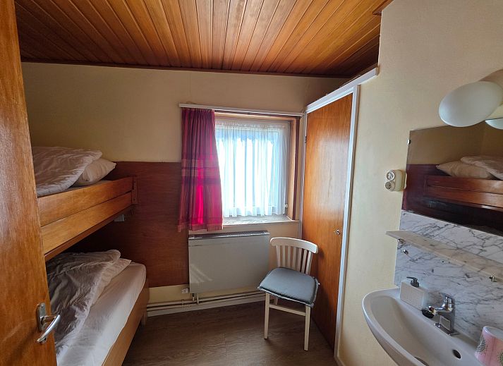 Gezellige woonkamer van Bungalow 47 in Bungalowpark De Nagtegaal, De Koog, Texel met comfortabele stoelen en houten interieur.