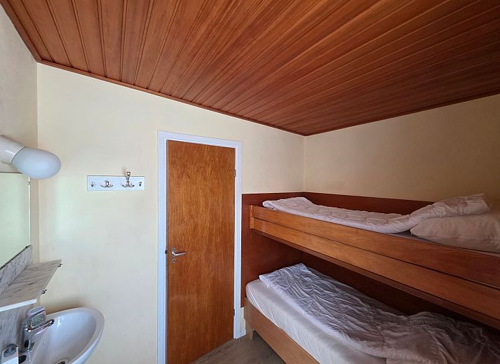 Gezellige woonkamer van Bungalow 47 in Bungalowpark De Nagtegaal, De Koog, Texel met comfortabele stoelen en houten interieur.