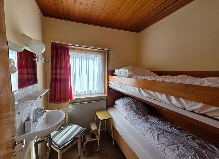 Gezellige woonkamer van Bungalow 47 in Bungalowpark De Nagtegaal, De Koog, Texel met comfortabele stoelen en houten interieur.