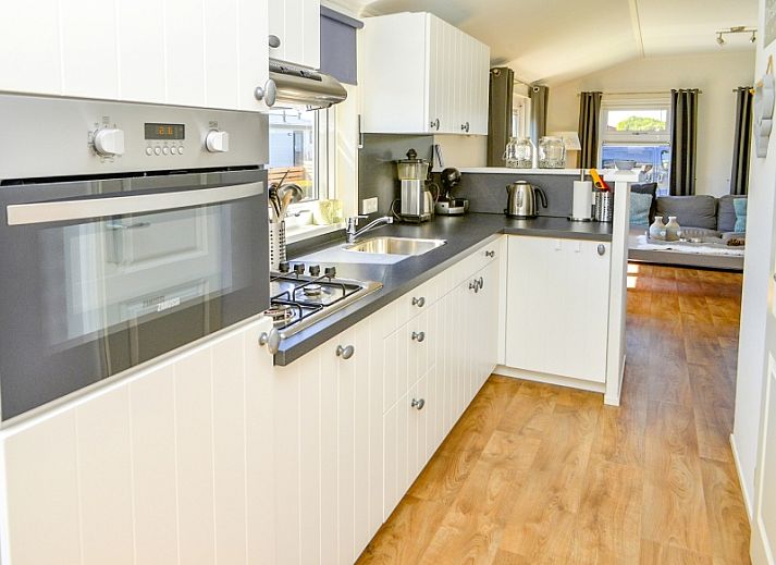 Gezellige woonkamer in Chalet Bregkoog 215 Zandhuisjes, Chaletpark Bregkoog, De Koog, Texel met comfortabele banken en houten vloer.