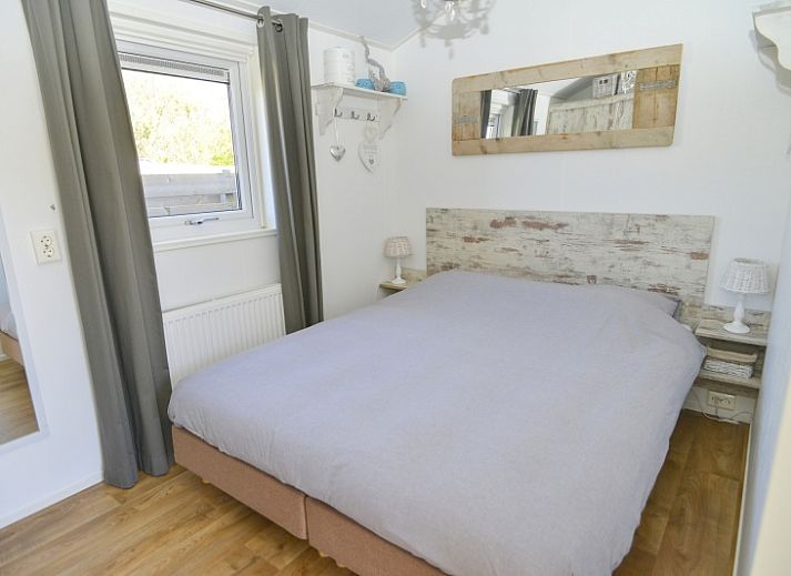 Gezellige woonkamer in Chalet Bregkoog 215 Zandhuisjes, Chaletpark Bregkoog, De Koog, Texel met comfortabele banken en houten vloer.