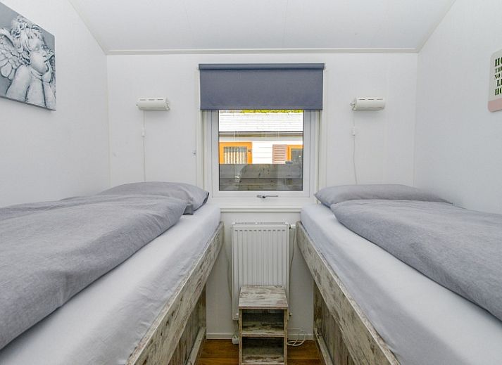 Gezellige woonkamer in Chalet Bregkoog 215 Zandhuisjes, Chaletpark Bregkoog, De Koog, Texel met comfortabele banken en houten vloer.