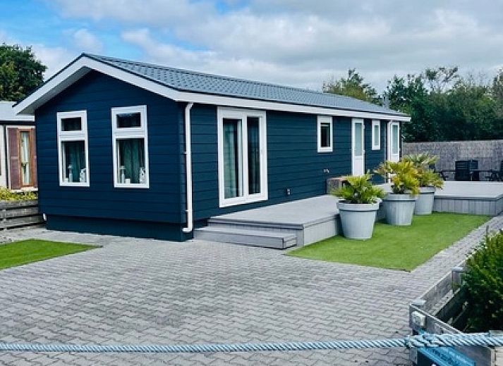 Gezellige woonkamer in Chalet Bregkoog 215 Zandhuisjes, Chaletpark Bregkoog, De Koog, Texel met comfortabele banken en houten vloer.