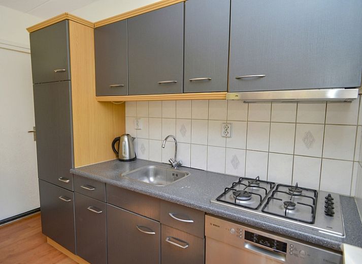 Gezellige woonkamer in Bungalowpark Hoog Koog - t Huisje Texel, De Koog, Texel, met comfortabele banken en kunst aan de muur.