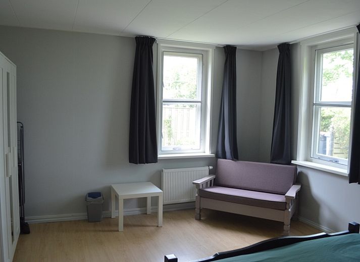 Seitenansicht von Hortensia, einem Ferienhaus in De Waal, Texel, umgeben von Blumen.