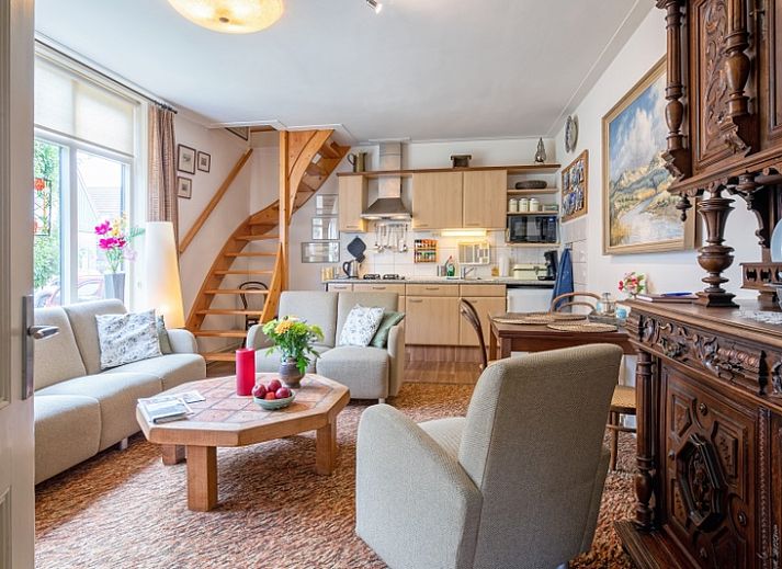 Charmanter Eingang zum Appartement Moleneind in De Waal, Texel, mit buntem Garten und Fahne.