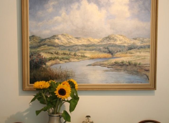 Charmanter Eingang zum Appartement Moleneind in De Waal, Texel, mit buntem Garten und Fahne.