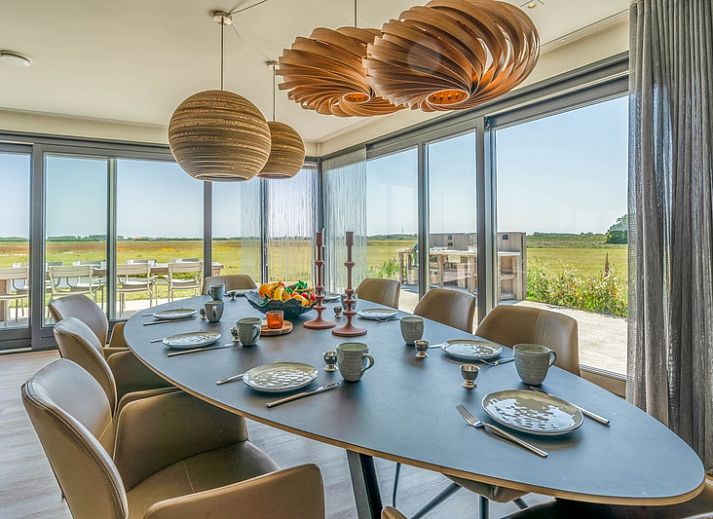 Gezellige woonkamer in Villa 16 Weegeswaal, Texel, met moderne inrichting en haard.