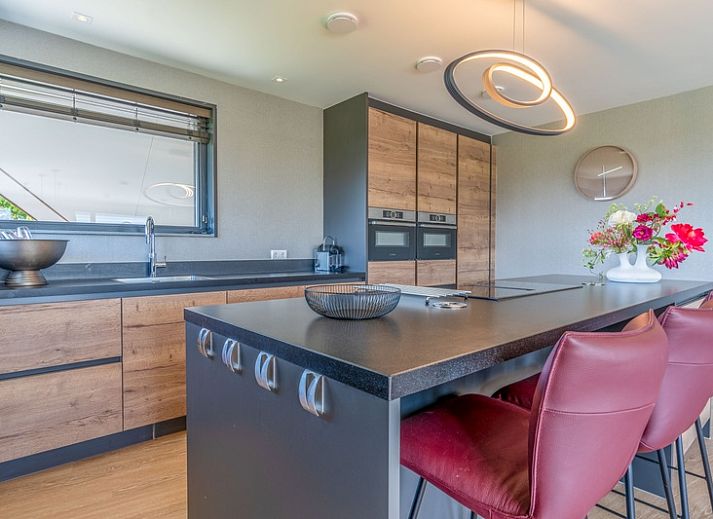 Gezellige woonkamer in Villa 16 Weegeswaal, Texel, met moderne inrichting en haard.