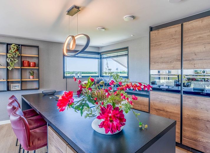 Gezellige woonkamer in Villa 16 Weegeswaal, Texel, met moderne inrichting en haard.