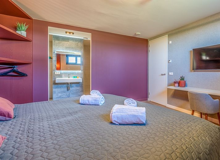 Gezellige woonkamer in Villa 16 Weegeswaal, Texel, met moderne inrichting en haard.