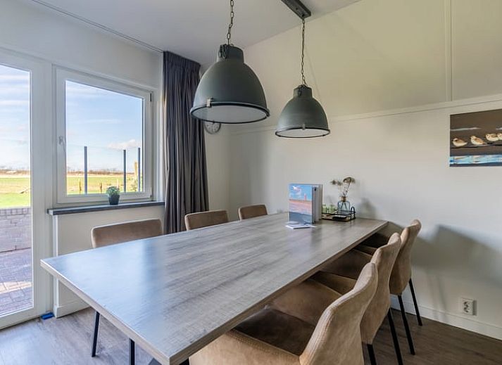 Modern living room in Holiday home in De Waal, Texel with comfortable corner sofa and views of nature.