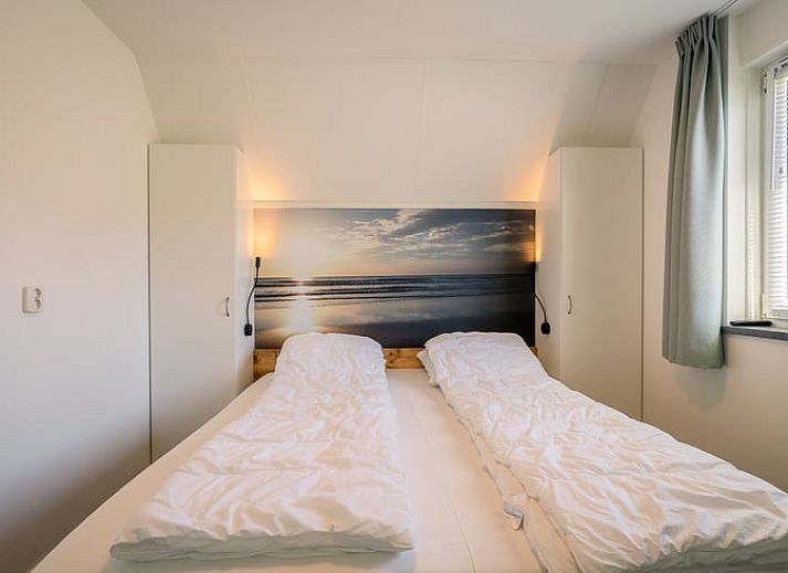 Modern living room in Holiday home in De Waal, Texel with comfortable corner sofa and views of nature.