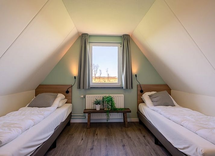 Modern living room in Holiday home in De Waal, Texel with comfortable corner sofa and views of nature.