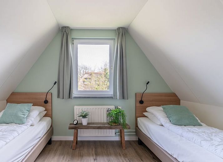 Modern living room in Holiday home in De Waal, Texel with comfortable corner sofa and views of nature.