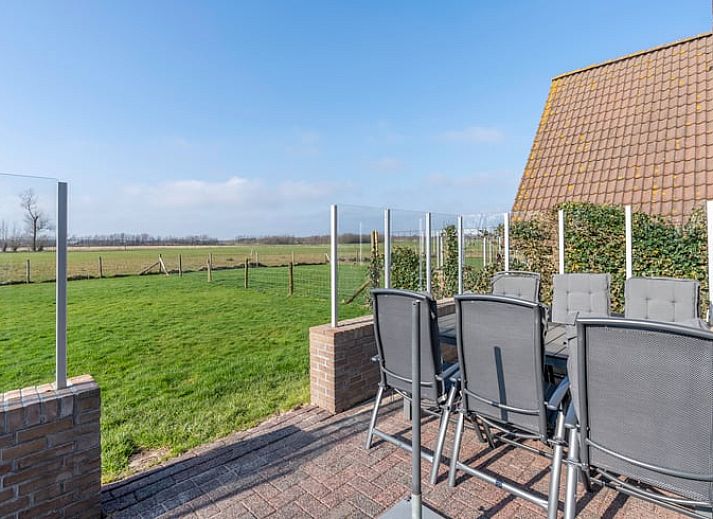 Cozy sitting area in Holiday Home in De Waal, Texel with flat-screen TV and atmospheric lighting.