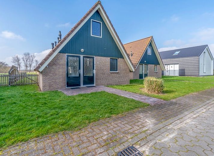 Cozy sitting area in Holiday Home in De Waal, Texel with flat-screen TV and atmospheric lighting.