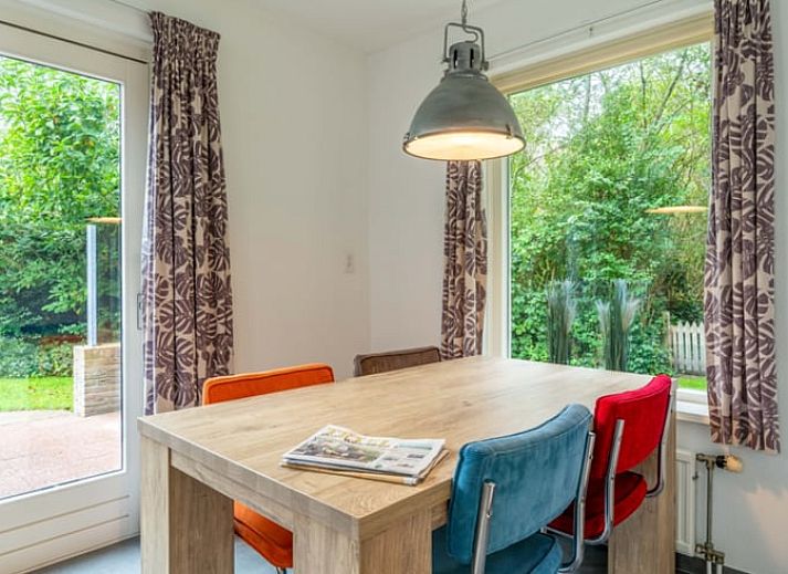 Gezellige woonkamer in Huisje in De Waal, Texel met comfortabele leren banken en veel natuurlijk licht.
