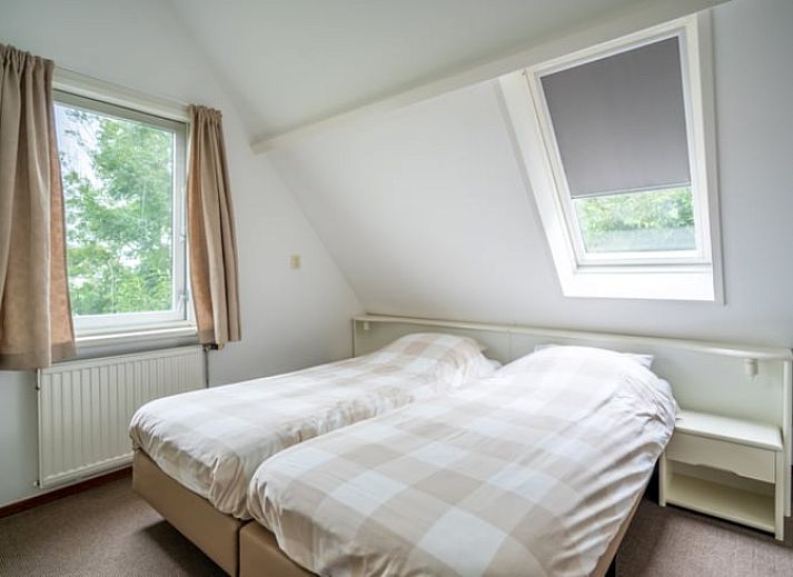 Gezellige woonkamer in Huisje in De Waal, Texel met comfortabele leren banken en veel natuurlijk licht.