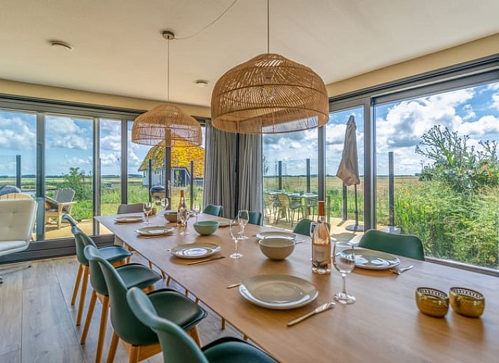 Lichte woonkamer in Vakantiehuisje in De Waal, Texel met moderne inrichting en uitzicht op de tuin.