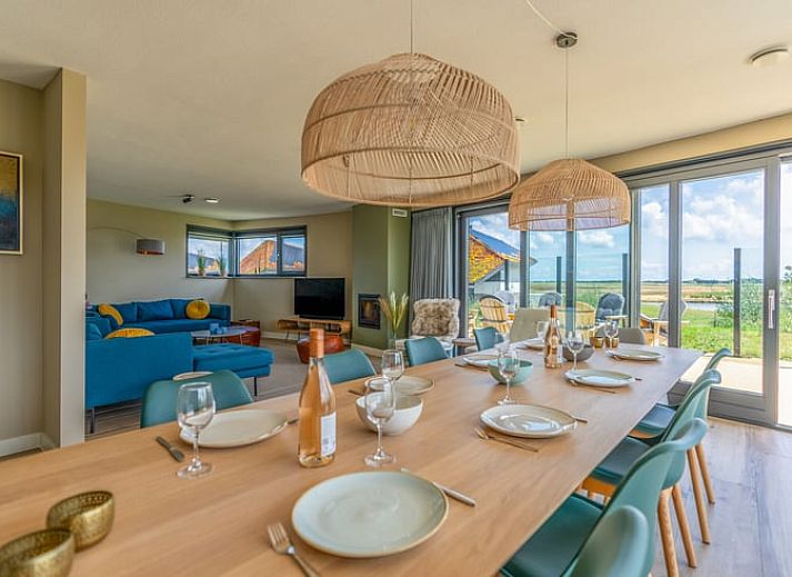 Lichte woonkamer in Vakantiehuisje in De Waal, Texel met moderne inrichting en uitzicht op de tuin.