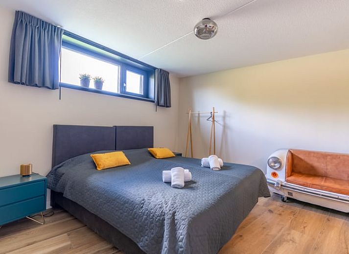 Lichte woonkamer in Vakantiehuisje in De Waal, Texel met moderne inrichting en uitzicht op de tuin.