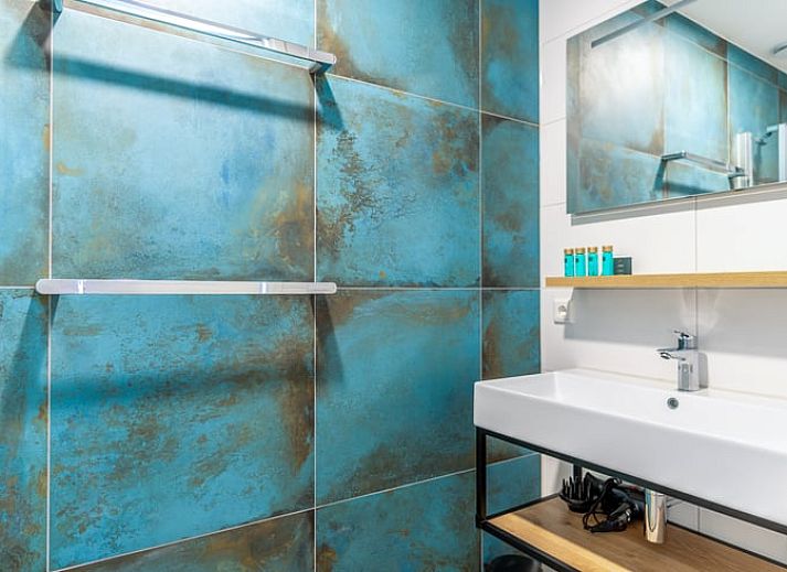 Stijlvolle woonkamer met blauwe banken in Vakantiehuisje in De Waal, Texel.