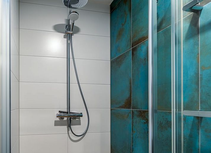 Stijlvolle woonkamer met blauwe banken in Vakantiehuisje in De Waal, Texel.