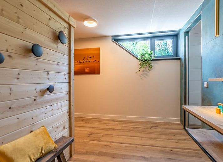 Stijlvolle woonkamer met blauwe banken in Vakantiehuisje in De Waal, Texel.