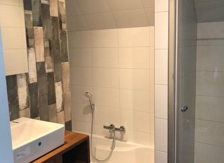 Gezellige eetkamer in Nieuwlanderweg 75 bungalow, De Koog, Texel met moderne inrichting en veel natuurlijk licht.