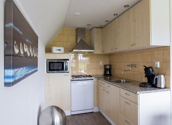 Comfortabele slaapkamer met tweepersoonsbed in Nieuwlanderweg 75 vakantiehuis, De Koog, Texel, met een rustgevend stranddecor.