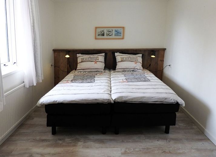 Charmante tuin bij Bungalow 0983 in Den Burg Texel, vakantiehuis met kleurrijke bloemen en groene omgeving.