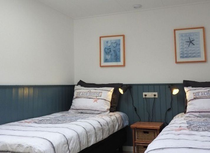 Charmante tuin bij Bungalow 0983 in Den Burg Texel, vakantiehuis met kleurrijke bloemen en groene omgeving.