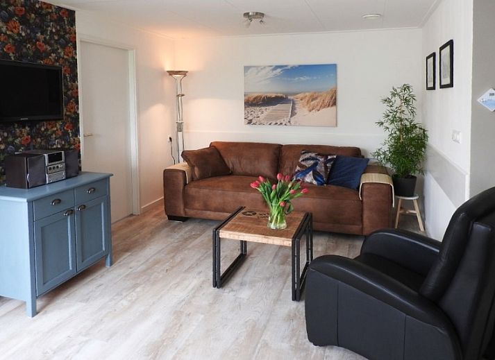 Charmante tuin bij Bungalow 0983 in Den Burg Texel, vakantiehuis met kleurrijke bloemen en groene omgeving.