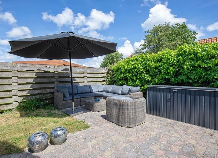 Zijaanzicht van Villa Magnifique, een vakantiehuis in Den Burg Texel, omgeven door groen.