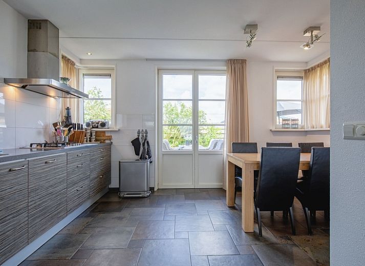 Zijaanzicht van Villa Magnifique, een vakantiehuis in Den Burg Texel, omgeven door groen.