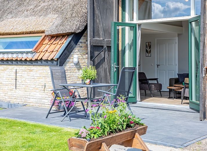 Gemuetliche Terrasse im Ferienhaus Het Schaap in Den Burg auf Texel, umgeben von viel Gruen.