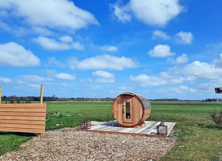 Gezellige woonkamer in Vakantiehuisje in Den Burg, Texel met modern interieur en uitzicht op de groene tuin.
