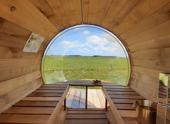 Gezellige woonkamer in Vakantiehuisje in Den Burg, Texel met modern interieur en uitzicht op de groene tuin.