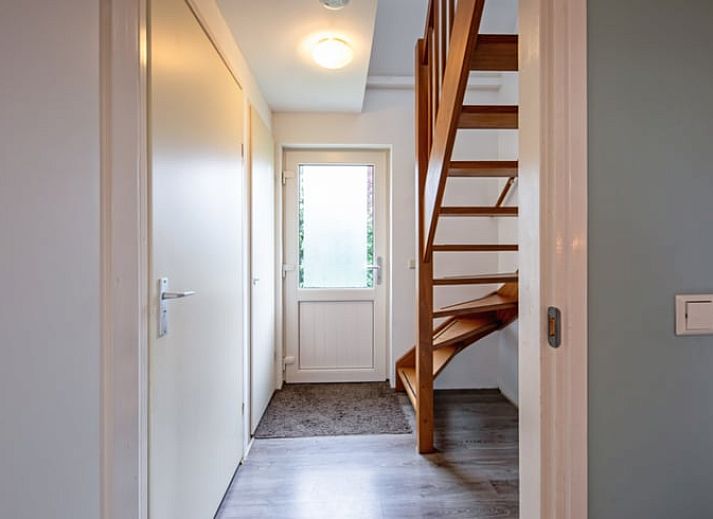 Gezellige woonkamer van Vakantiehuisje in Den Burg, Texel met comfortabele zithoek en uitzicht op de tuin, ideaal voor ontspanning.